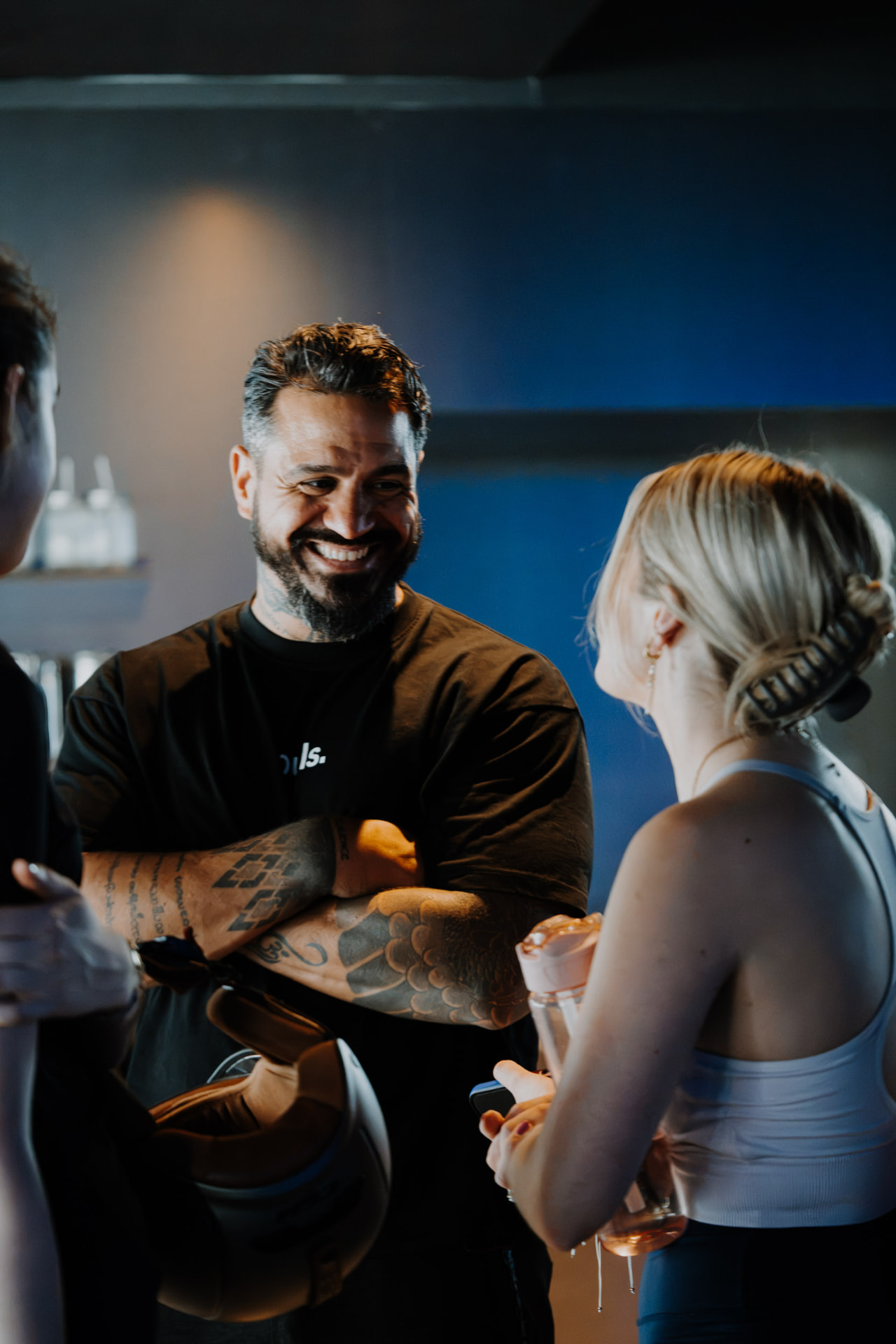 Coach laughing with members after a boxing session in the ONE PULS club, Brussels