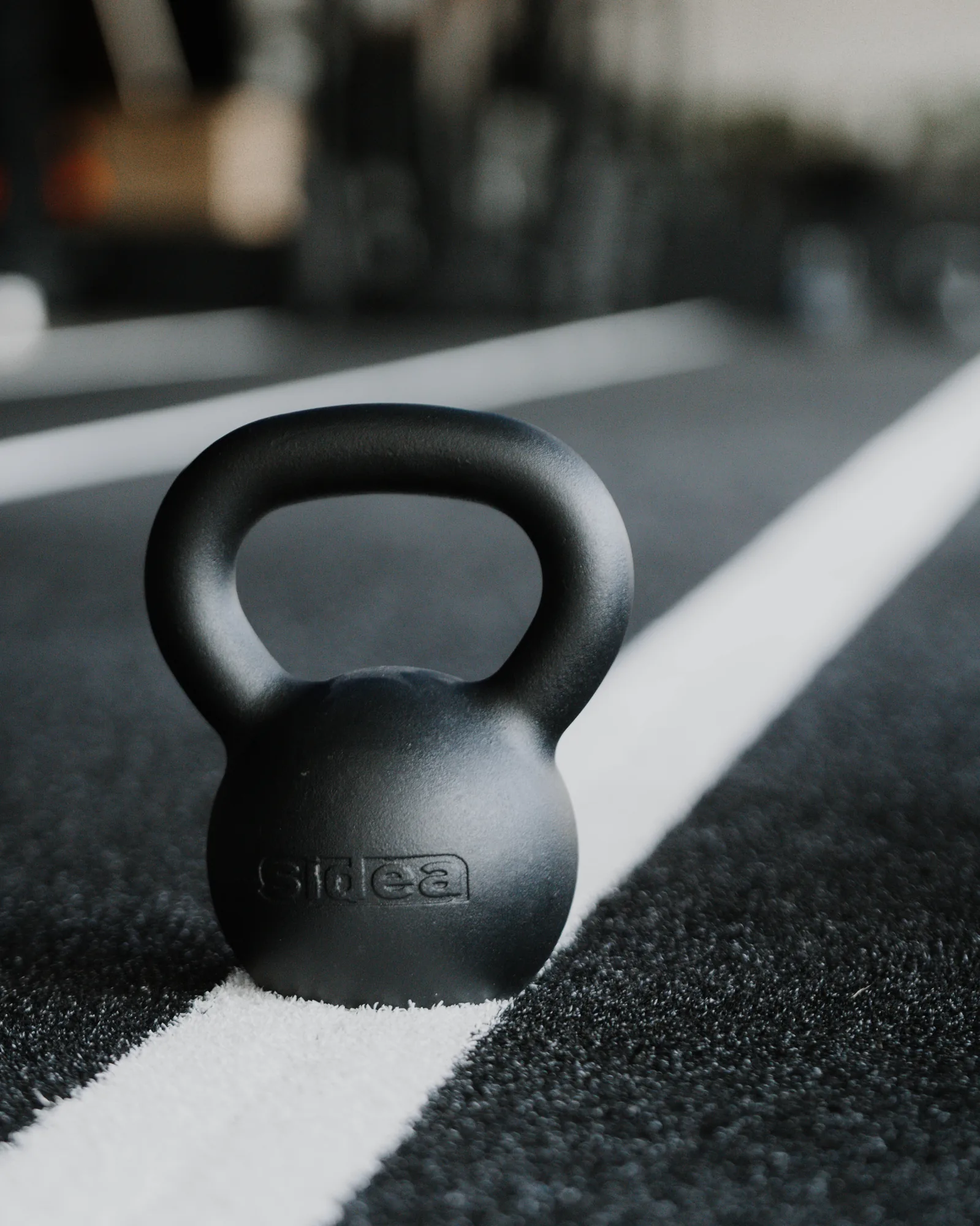 Kettlebell resting on the track of the ONE PULS HYROX studio in Brussels