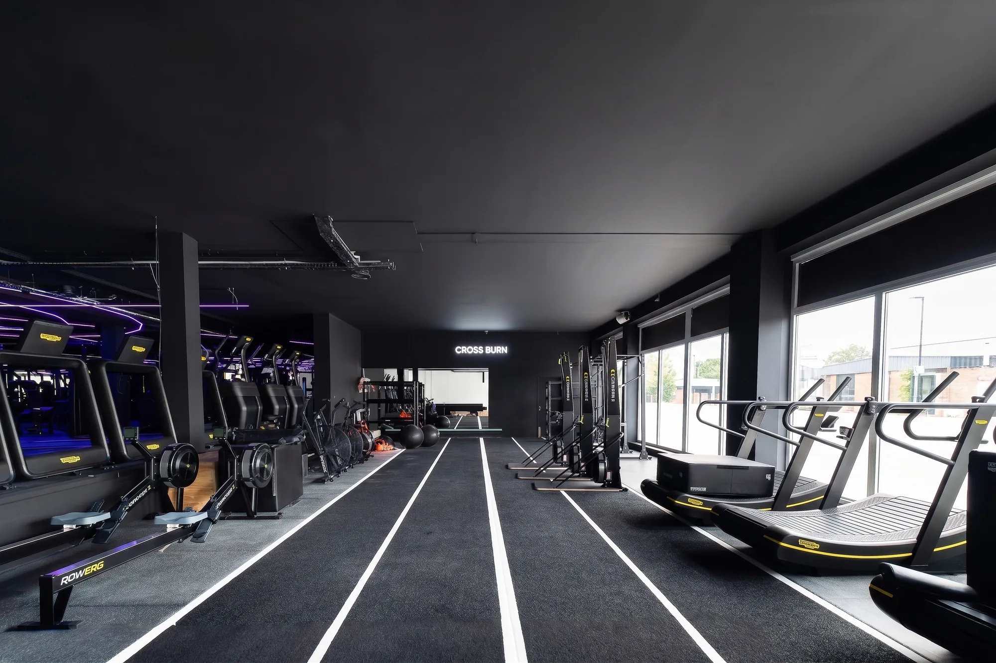 Salle HYROX avec rameurs, tapis et piste de sprint chez ONE PULS Bruxelles