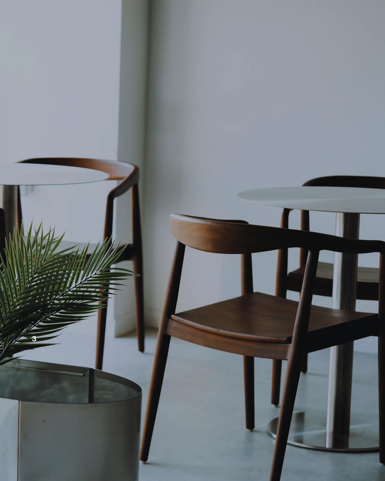 Chaises en bois et tables rondes dans le lounge ONE PULS à Forest, Bruxelles